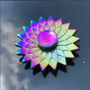 A rainbow metal fidget spinner with a multifaceted, sunburst design reflecting iridescent colors.