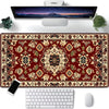 A vintage Persian rug gaming mouse pad with a non-slip rubber base is shown next to a computer monitor and keyboard.