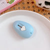 A light blue, oval-shaped mini cutter with a heart-shaped tip rests on a white plate.