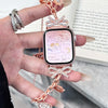 A close-up of a fashionable diamond butterfly watch strap attached to a smartwatch on a person's wrist.