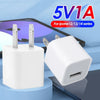 A white universal USB wall charger cube with multiple pins is shown next to a smartphone.