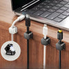 A set of magnetic cable organizer clips attached to a laptop, holding various charging cables.