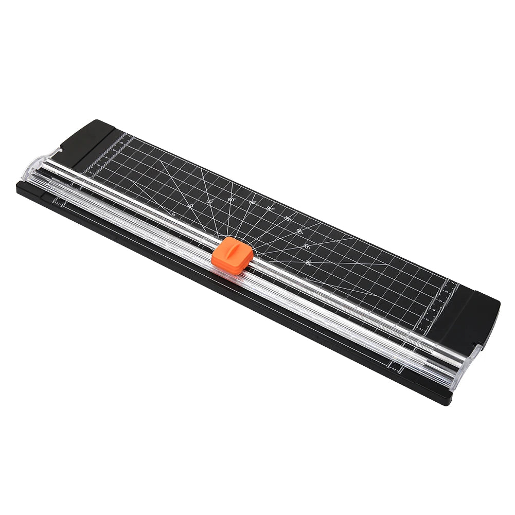 A portable manual paper trimmer with a clear plastic blade and a black body is shown at an angle.