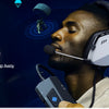 A man wearing a white gaming headset is using a device to boost audio, with sound waves visible around him.