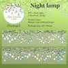 A display of decorative glass light bulbs hanging from branches, used as a night lamp.