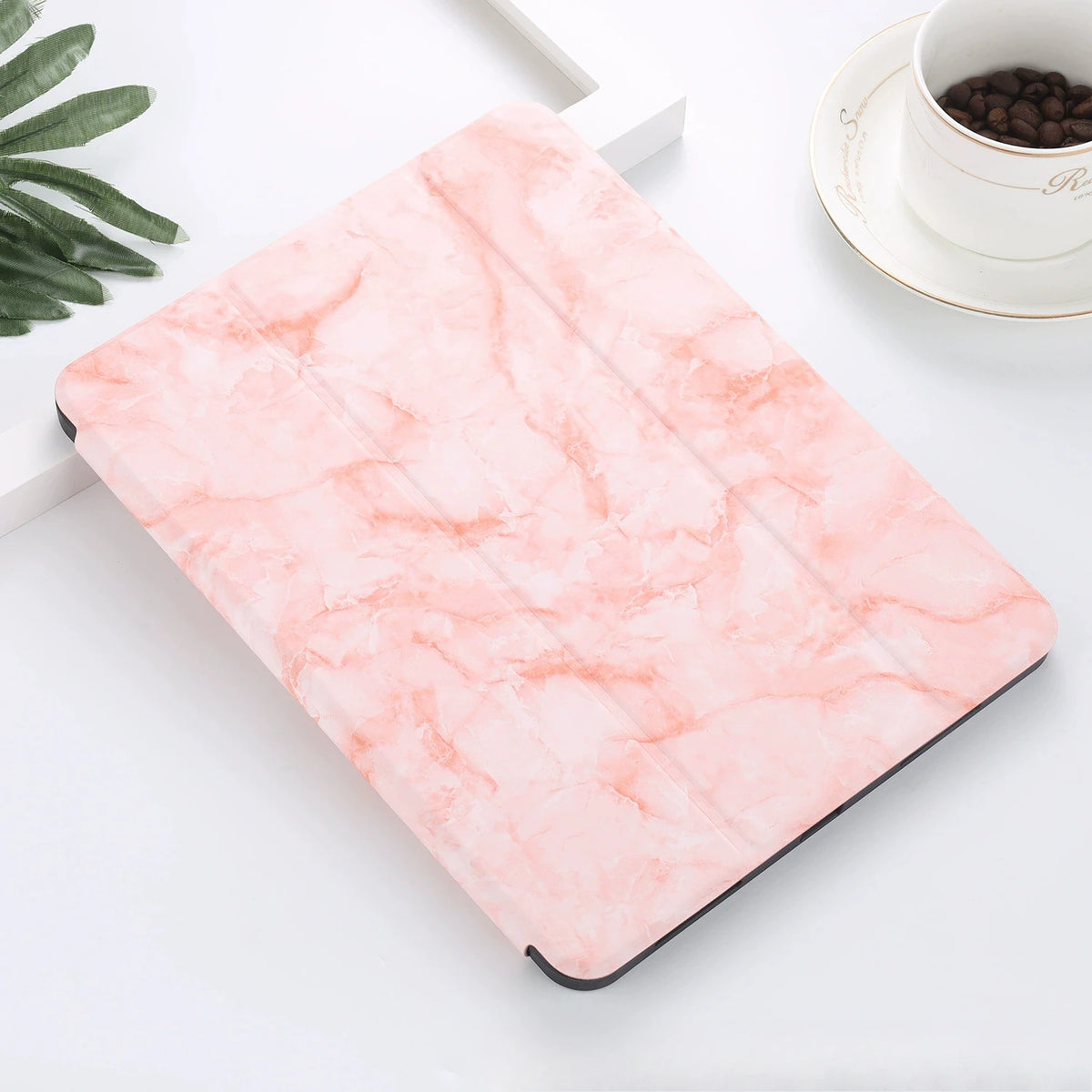 A pink marble-patterned silicone skin for an iPad Pro resting on a white surface.