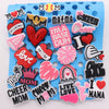 A collection of heart-shaped and text-based shoe charms in various colors like red pink and black for a personalized gift set
