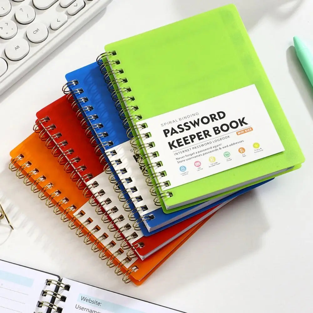 A stack of colorful spiral binding password keeper notebooks in green, blue, orange, and red on a white surface.