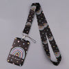 A black minimalist heart-shaped lanyard featuring a rainbow pattern and the text be kind