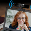 Eine Frau lächelt auf einem Laptopbildschirm und demonstriert ein Geräuschreduzierendes Mikrofon-Setup.