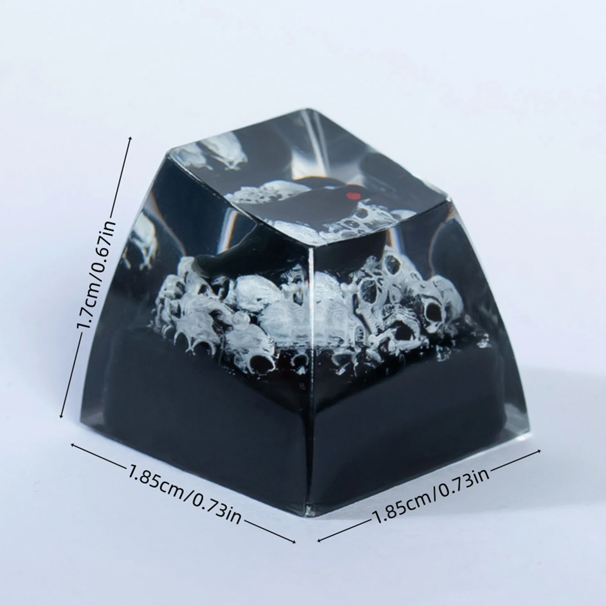 A black resin keycap shaped like a gothic raven with a skull design.