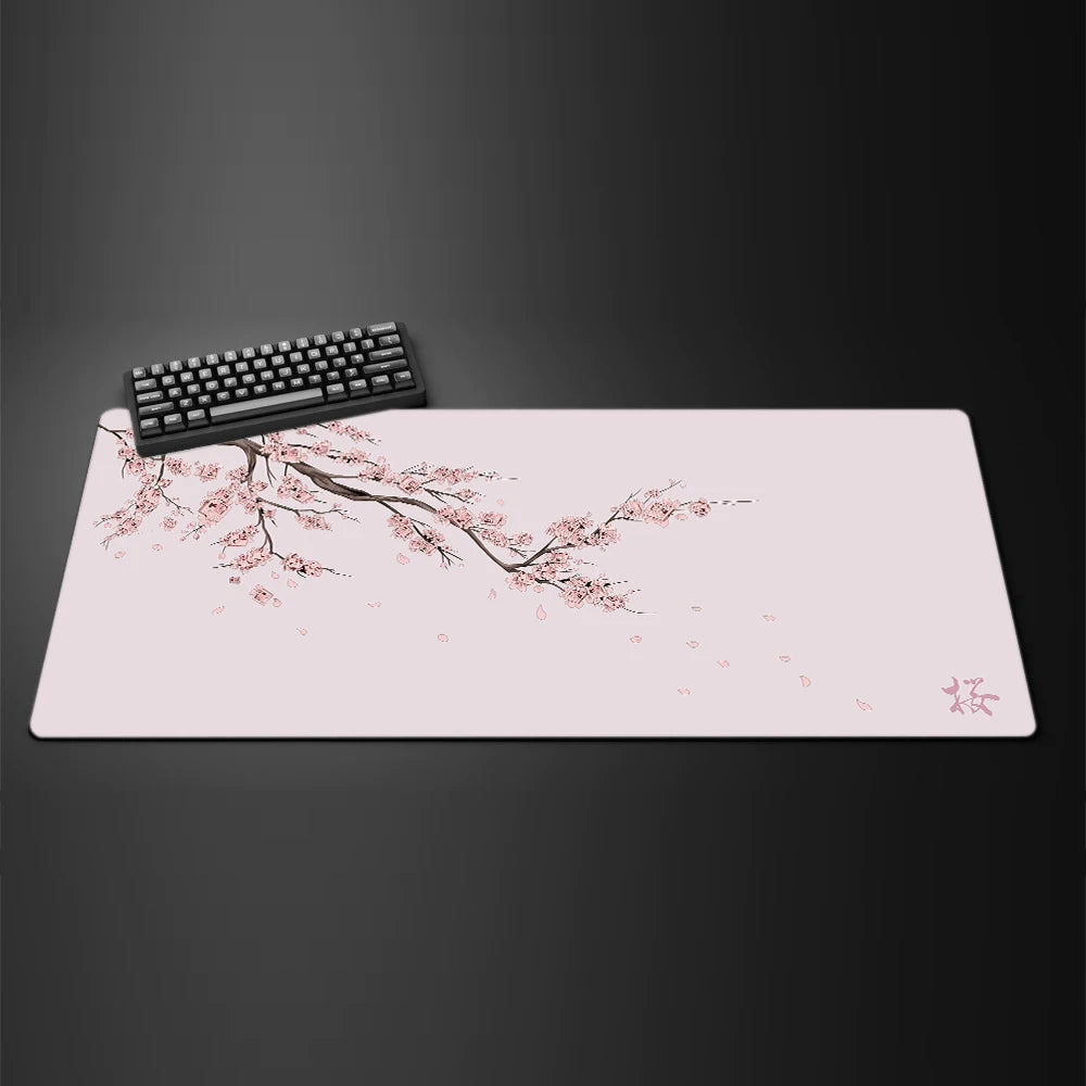A pink gaming mouse pad featuring delicate cherry blossom branches and petals on a dark background.