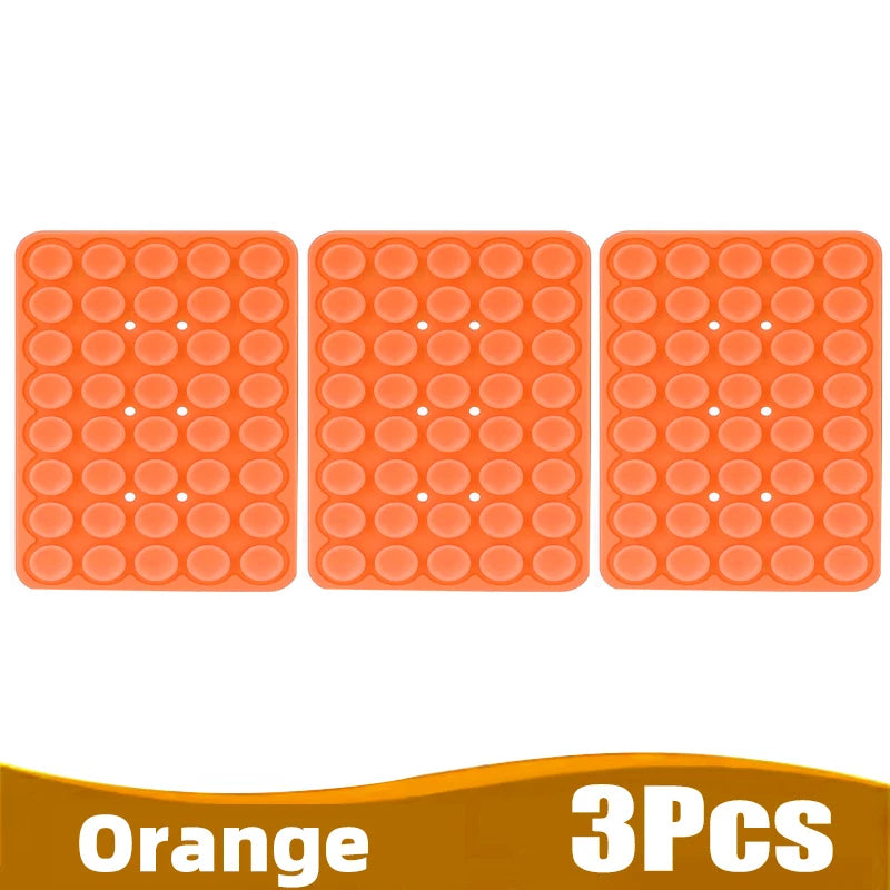 Three orange silicone suction cup phone holders arranged in a row.