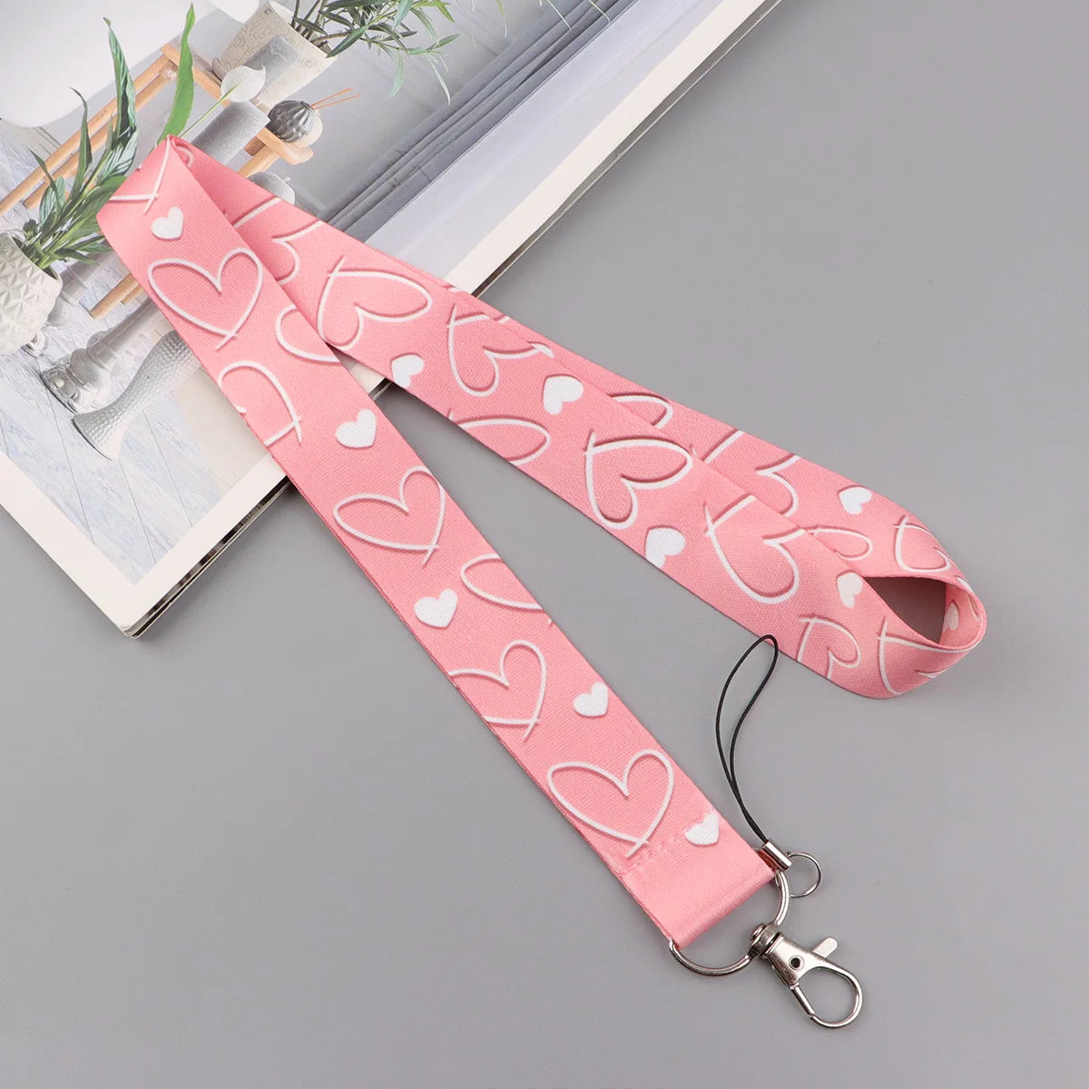 Pink heart-shaped lanyard with a repeating pattern for badges and keys