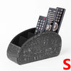 A black PU leather remote control holder with five compartments displaying various engraved patterns.