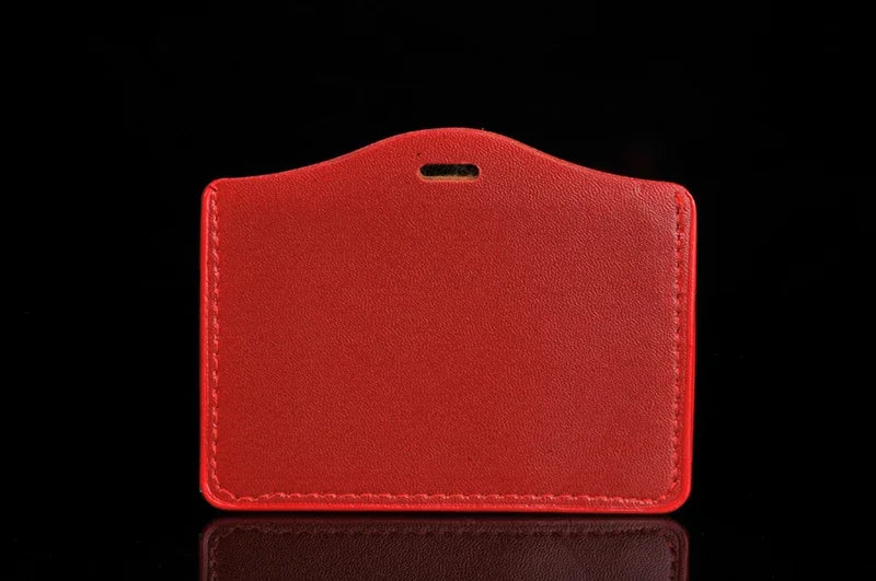 A red PU leather retractable ID card holder with a black clip against a dark background.