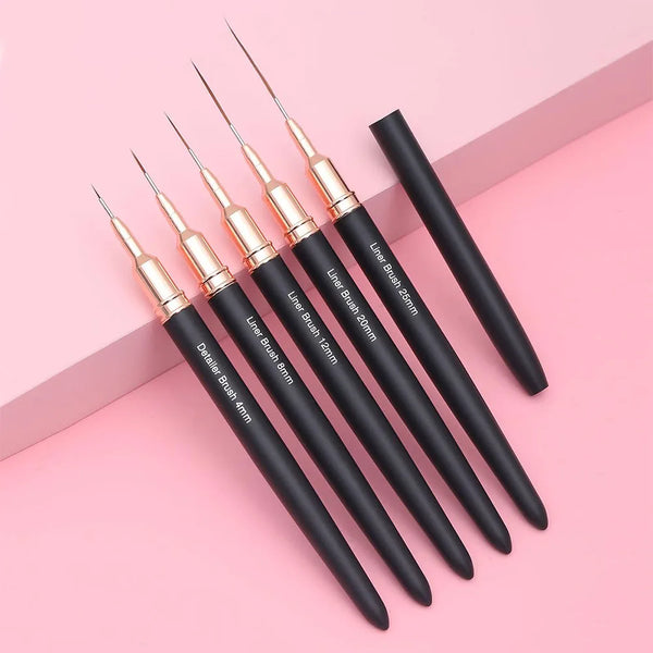 Ein Set präziser Nagelliner-Pinsel in Gold und Schwarz auf rosa Hintergrund.