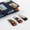 A dark blue journal or pen holder with brass and leather clips and a pen inside.