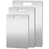 A set of three stainless steel double-sided cutting boards stacked vertically.