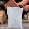 Hands holding a brown rock and a white self-seal shipping bag.