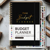 A black and gold undated monthly budget planner notebook with various budget tracking sheets and tools.