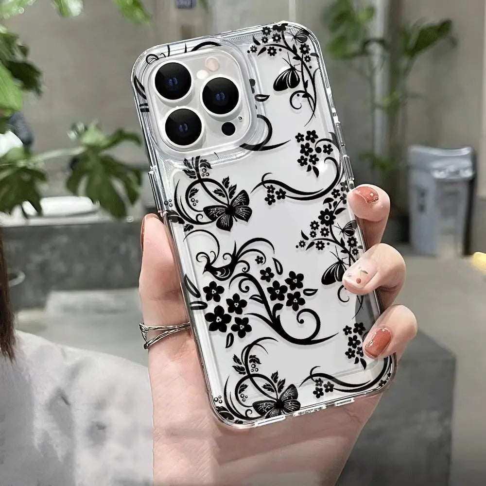 A hand holds a clear phone case with a black floral pattern and multiple camera lenses.