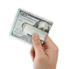 A hand holds a folded hundred dollar bill, showing the Federal Reserve note and serial number.