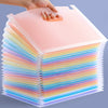 A hand places a pink multi-layer storage file rack filled with colorful vertical files onto a surface.