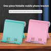Two one-piece foldable mobile phone brackets in teal and pink colors displayed on a wooden surface.