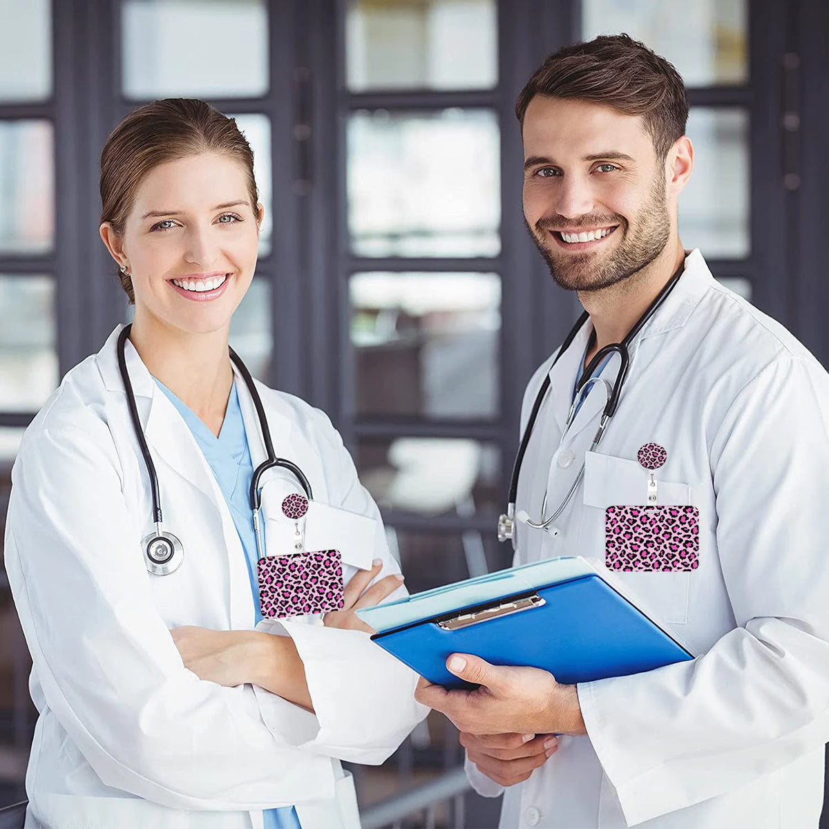 A smiling female doctor and male doctor in white lab coats holding a blue badge holder with a leopard print retractable badge