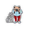 An enamel pin featuring a frog character holding a camera and surrounded by affectionate Spanish phrases.