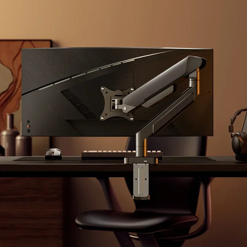 A black monitor is mounted on an adjustable desk monitor arm, positioned on a dark wooden desk.