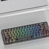 A close-up view of crystal clear RGB keycaps for a mechanical keyboard displayed on a glass surface.