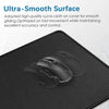 A black mouse is placed on a large, smooth, black rubber mouse pad.