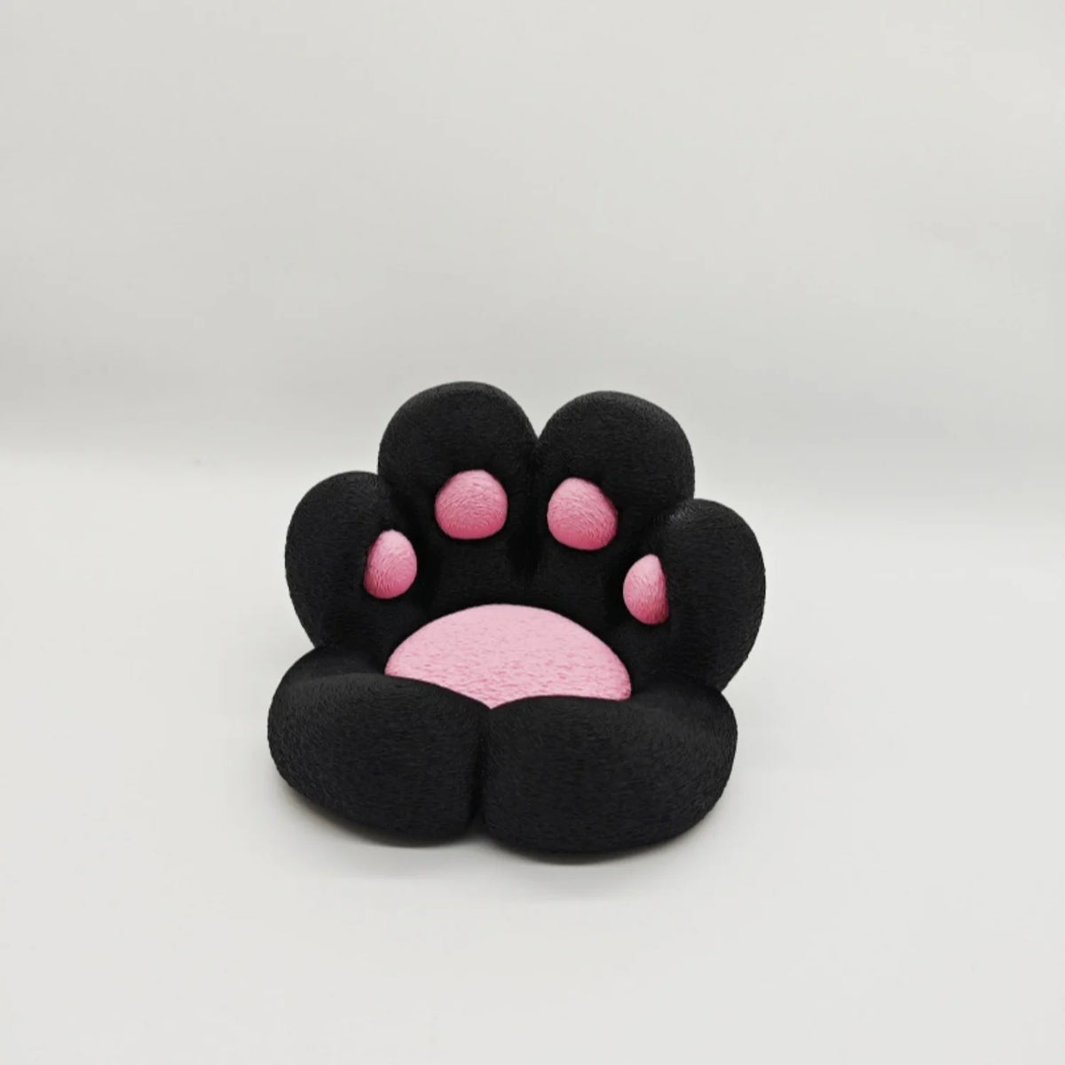 A black 3D printed cat paw phone stand with an anti-slip base featuring pink accents.