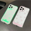 A pair of clear silicone glow cases with pink and green accents for an iPhone, featuring a bowknot design.