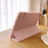 A pink magnetic protective case for an iPad, shown open on a wooden table.