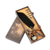 A wooden box containing a black feather dip pen and other calligraphy tools on a map background