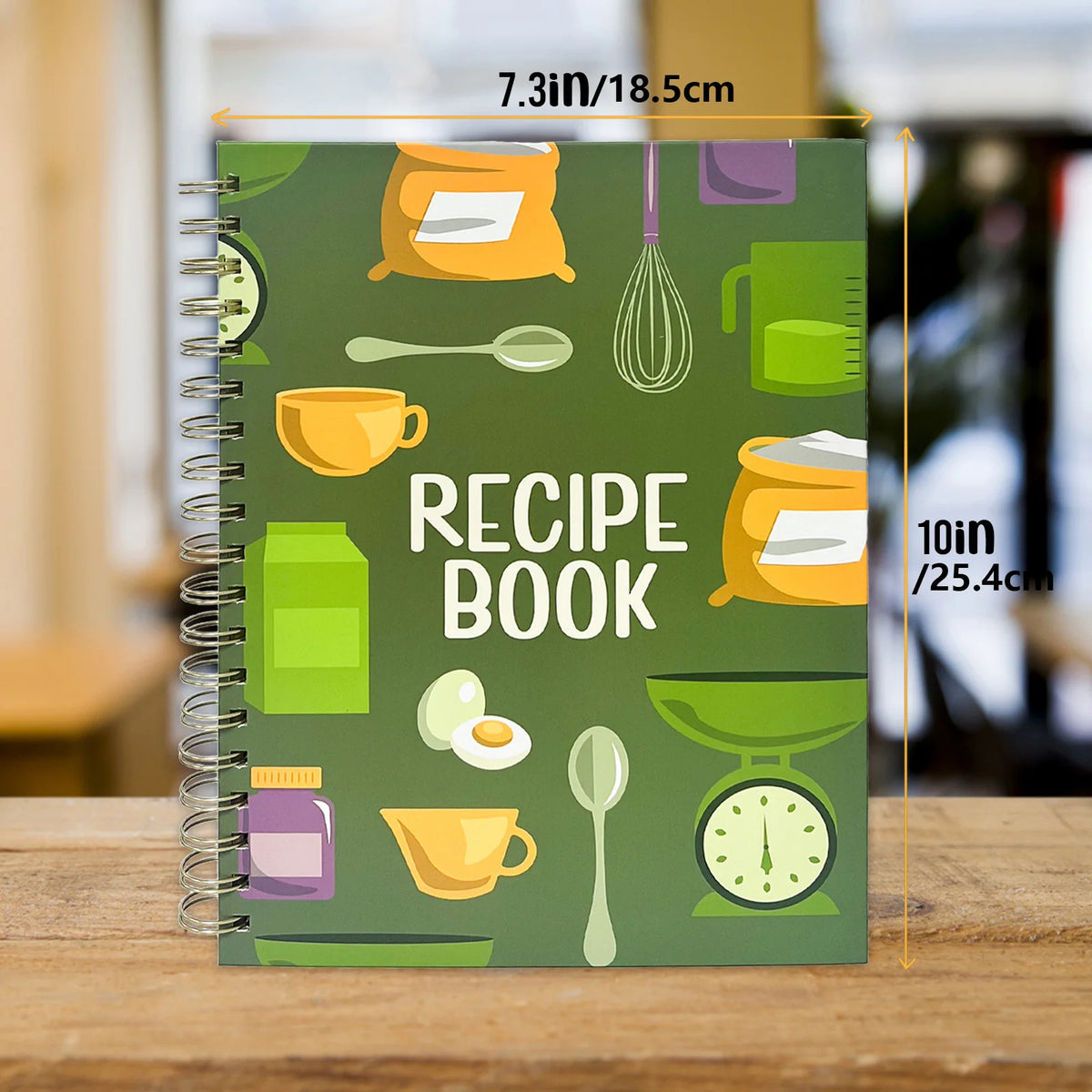 A green recipe book with various kitchen tools and ingredients illustrated on the cover.