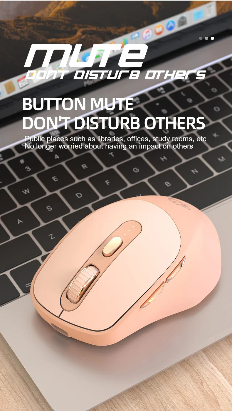 A pink wireless computer mouse is shown resting on a wooden surface next to a laptop keyboard.