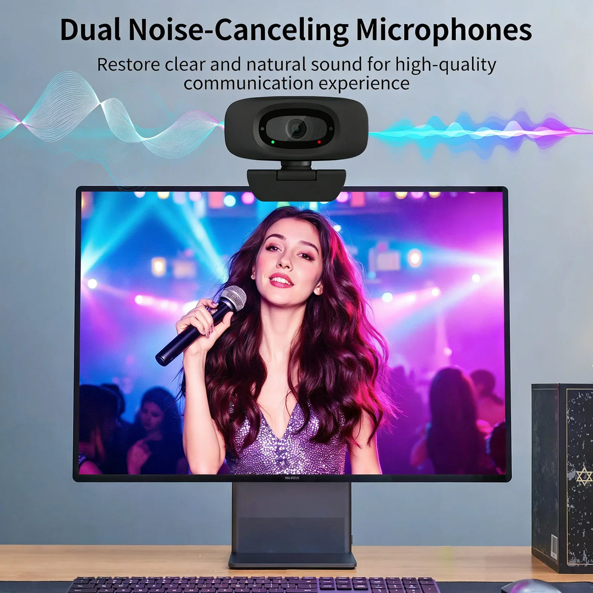 A dual noise-canceling microphone camera is positioned above a monitor displaying a woman singing into a microphone.
