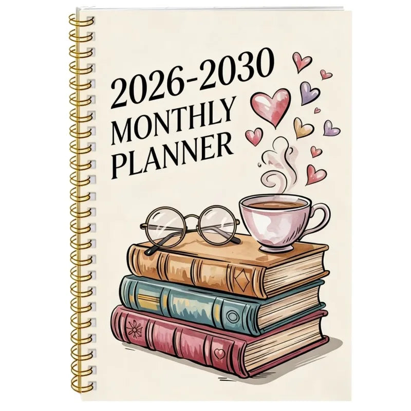 A spiral-bound monthly planner for 2026-2030 featuring decorative hearts and a cup of coffee resting on a stack of books.