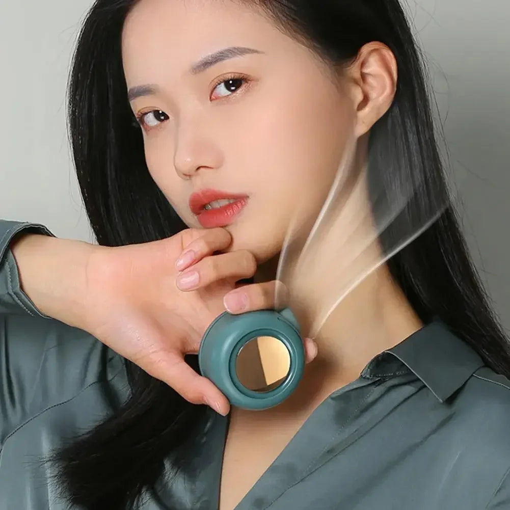 A woman is using a portable mini blade-less electric fan, which is a small, round device with a translucent casing.