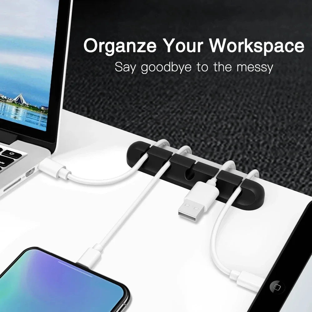 A silicone cable organizer set with multiple white cables and a USB plug is shown on a laptop workspace.