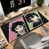 A black gaming mouse pad featuring anime characters and text displayed on a wooden desk.