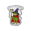 An enamel pin featuring a green frog wearing a wizard hat and cloak, with a staff and a skull.