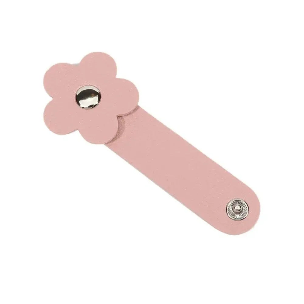 A pink leather flower cable organizer used as a reusable cord winder.