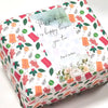 A rectangular gift box decorated with floral and leaf patterns, featuring a message inside.