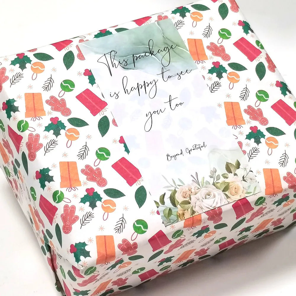 A rectangular gift box decorated with floral and leaf patterns, featuring a message inside.