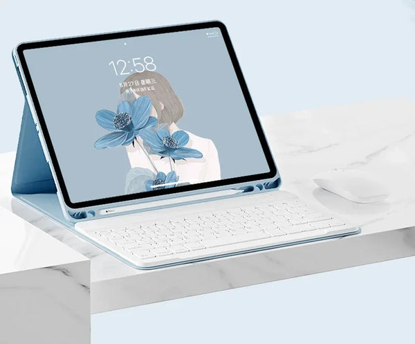 A silver magnetic keyboard case for an iPad Pro is shown open on a white marble surface.
